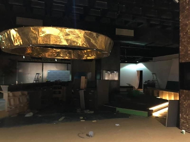 Interieur in afbouw met een grote goudkleurige ring aan het plafond en verlichte trede
