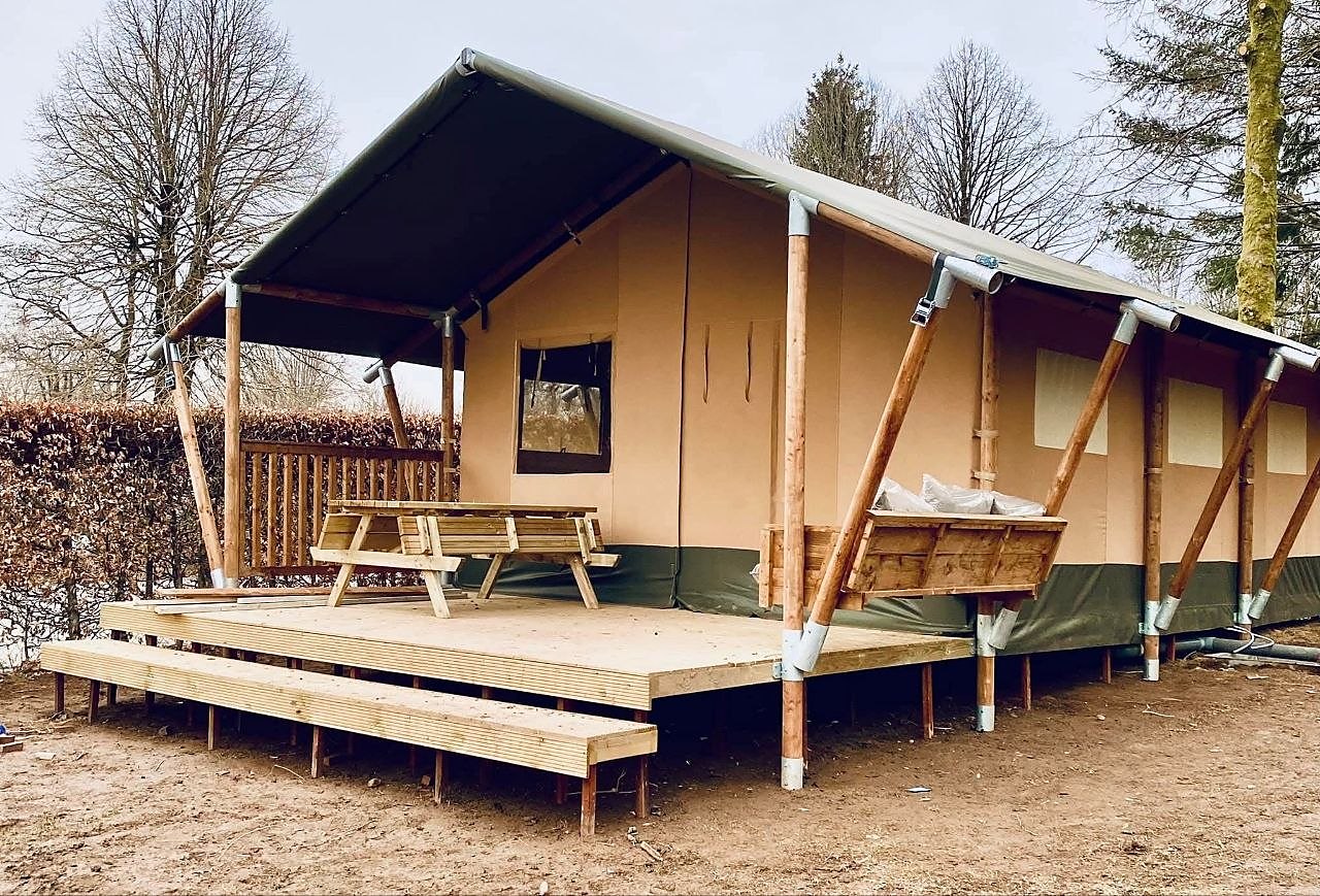 Safaritent op houten poten met vlonderterras, picknicktafel en trap