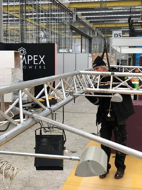 Vakman monteert een aluminium truss op een beursvloer